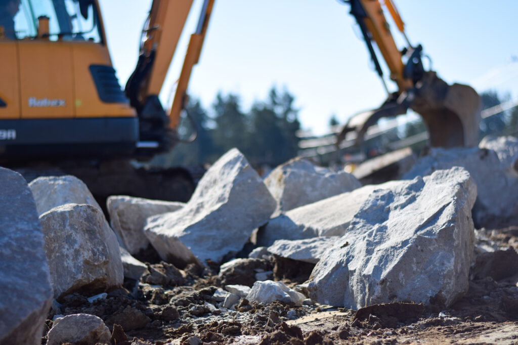 Earthmover focused on Boulder Wall Construction from your Breaking Ground Excavation Contractor