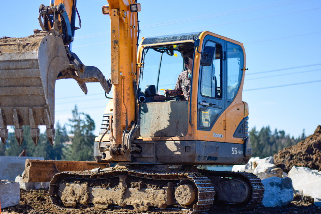 Earthmover working to build as a boulder retaining wall